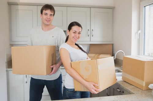 Professional movers handling boxes and furniture in a flat